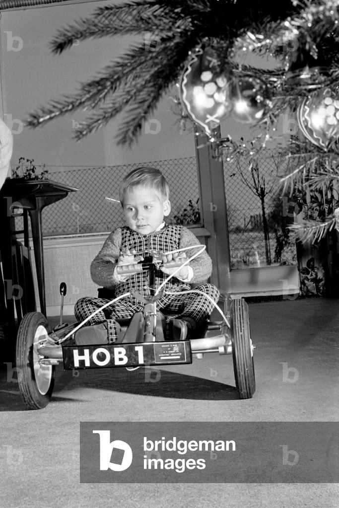 David Smith, a bright three year old from Pattingham, Staffordshire as you can see Santa arrived early this year for David bring a shining new Go Kart. However it is no ordinary Kart but Davids only method of transport for he is a victim of Spina Bifida and has no real use in his legs. The Kart has been specially designed and made by apprentices at a large Wolverhampton, Engineering Factory and was presented to David this week. The Kart which is used by David inside and outside his home is even fitted with a reverse gear. Now Home Office Officials are interested in producing the Kart in Prisons and Borstal Institution and it should sell for approximately £20. December 1969