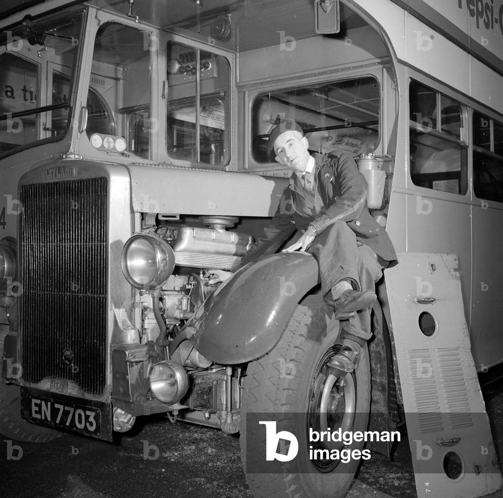 London Transport mechanic seen here checking the engine of a Leyland bus.
Circa 1957