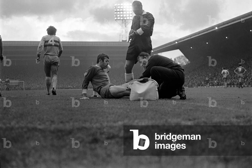 English League Division One match at AnfieldLiverpool 2 v West Ham United 0. Goalkeeper Ferguson injured after he made a daring dive at the feet of Liverpool winger Ian Callaghan and teammate Howe. Both fell and landed on top of him. November 1969 (photo)