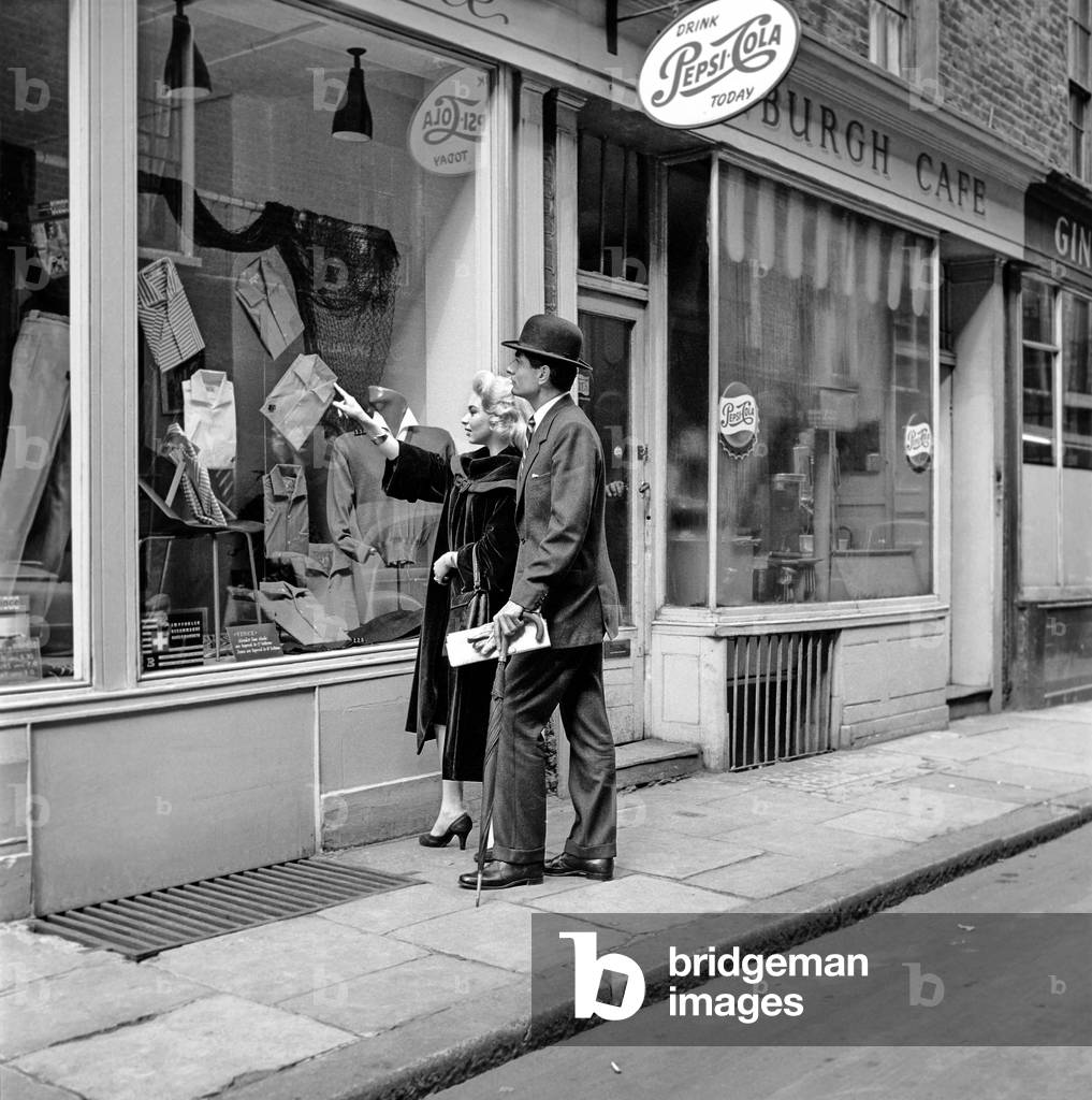 Clothing men's and womens fashions 1957: Models Michael Stanley and Bernice Swanson try on the latest fashions at Vinci's mans shop in Newburgh street London. May 1957 (b/w photo)