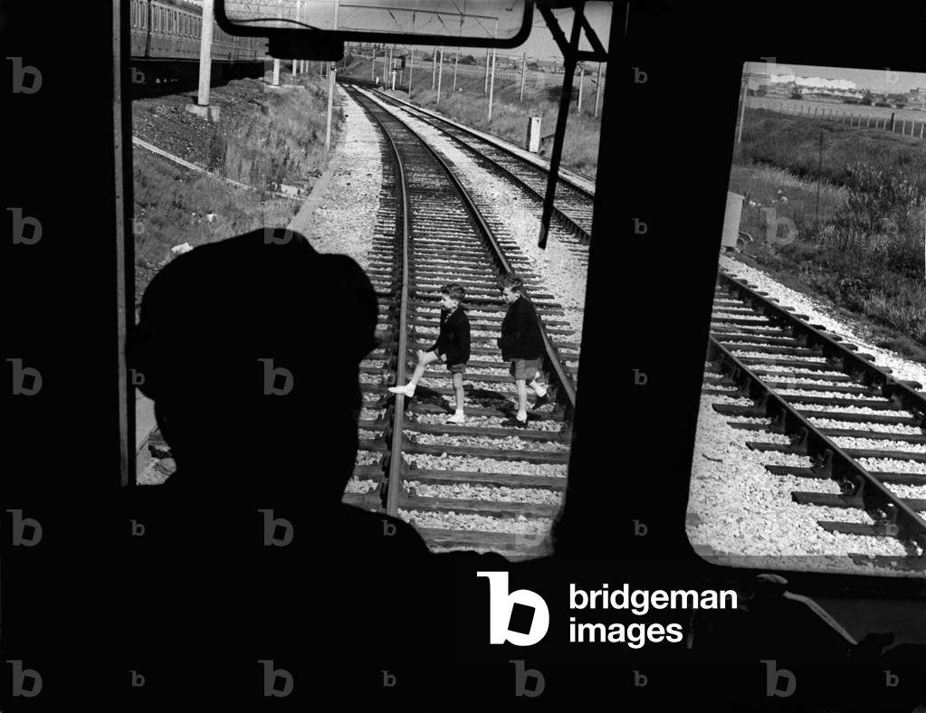 Driver George Thomas at the controls of his train as children dash across the line. This is a reconstruction picture of what happened. July 1961