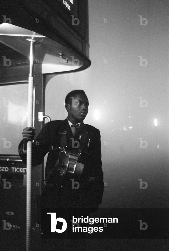 Weather London Smog December 1962. A London Transport bus conductor looks out from the platform of his Routemaster bus during the London Smogs of December 1962