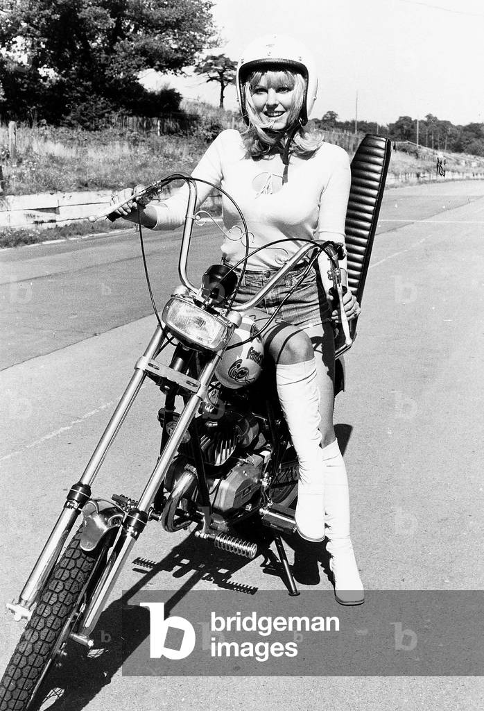 Motor Cycles model rides Fanticmotor chopper bike, October 1974 (b/w photo)
