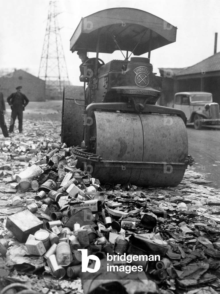 Piles of tin and aliminium cans are crushed by a giant steam roller for salvage as part of the effort to recycle used metal during the Second World War 
 January 1942