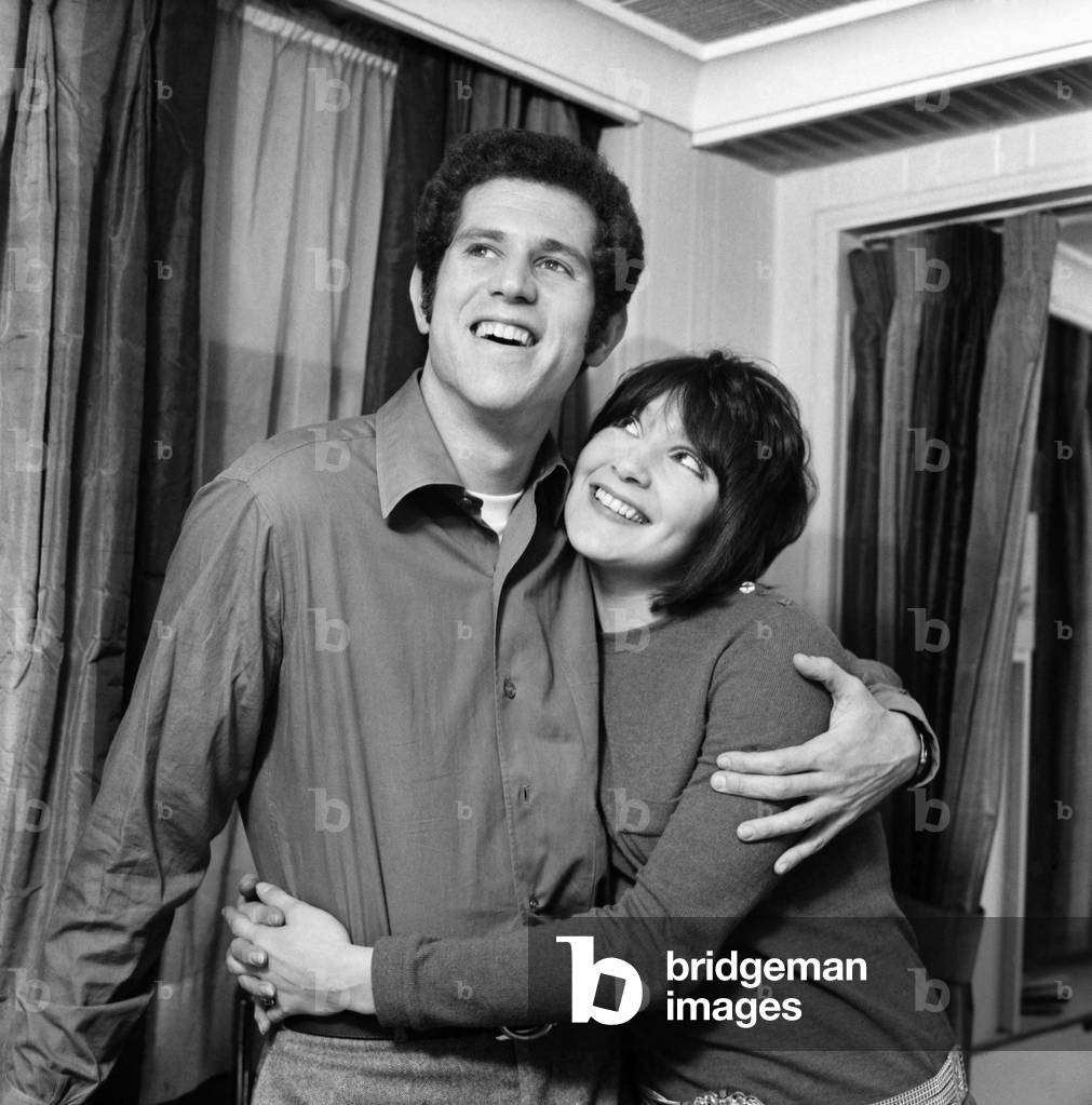 Couple embracing with the woman looking up to the man. December 1969