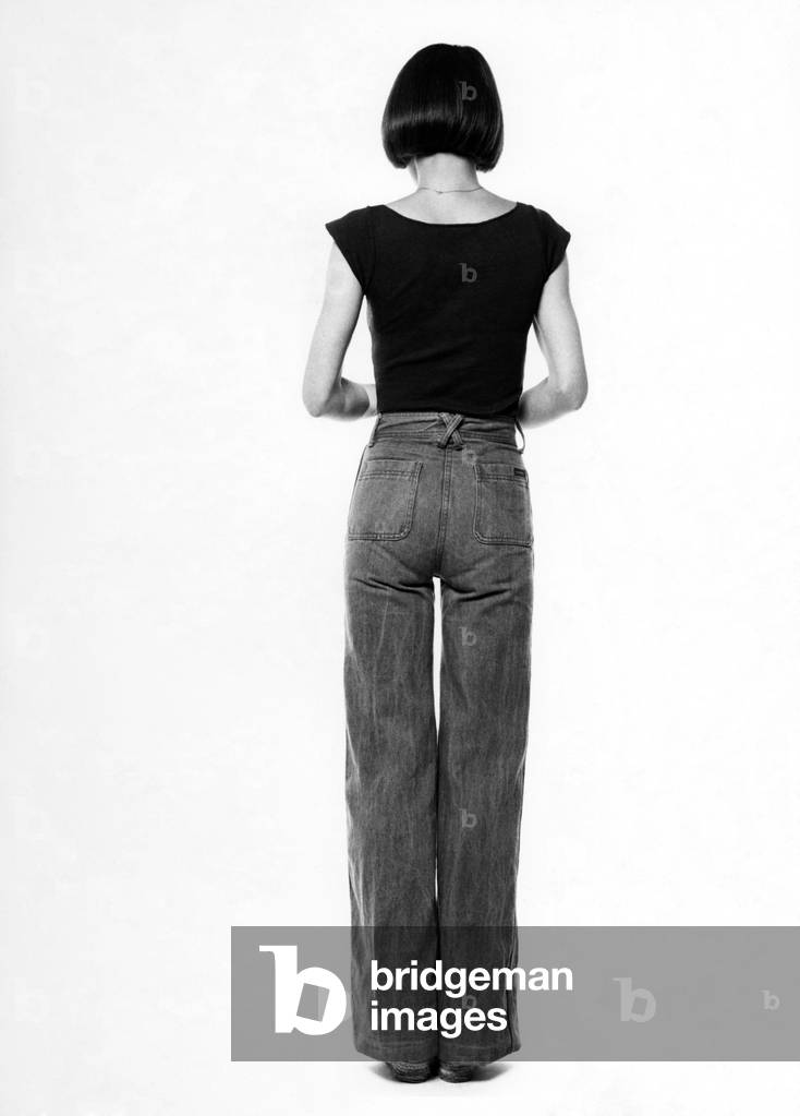 Fashion - 1970s. 
Back of woman. Jeans and t-shirt. 
October 1975
