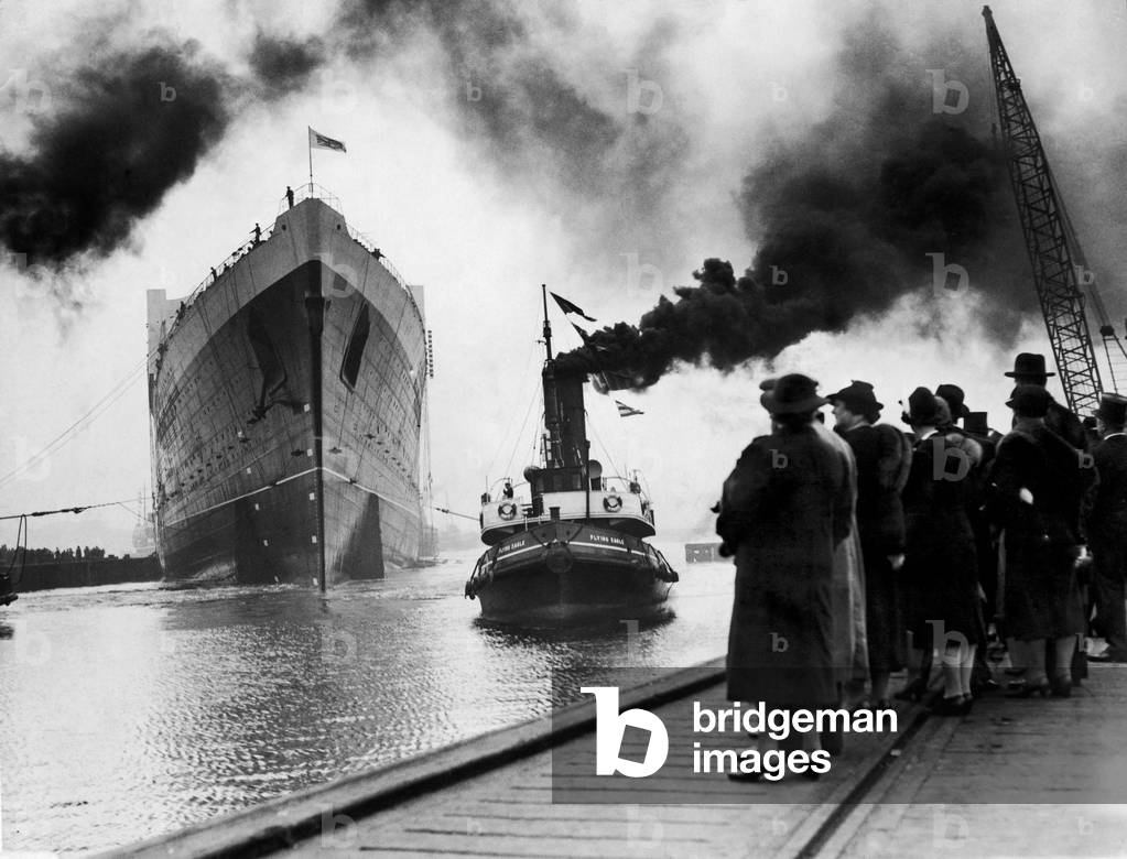 The launching of the Cunard Line luxury ocean liner RMS Queen Elizabeth at John Brown shipyard on the River Clyde, being pulled by tug The Flying Eagle 27th September 1938 (b/w photo)
