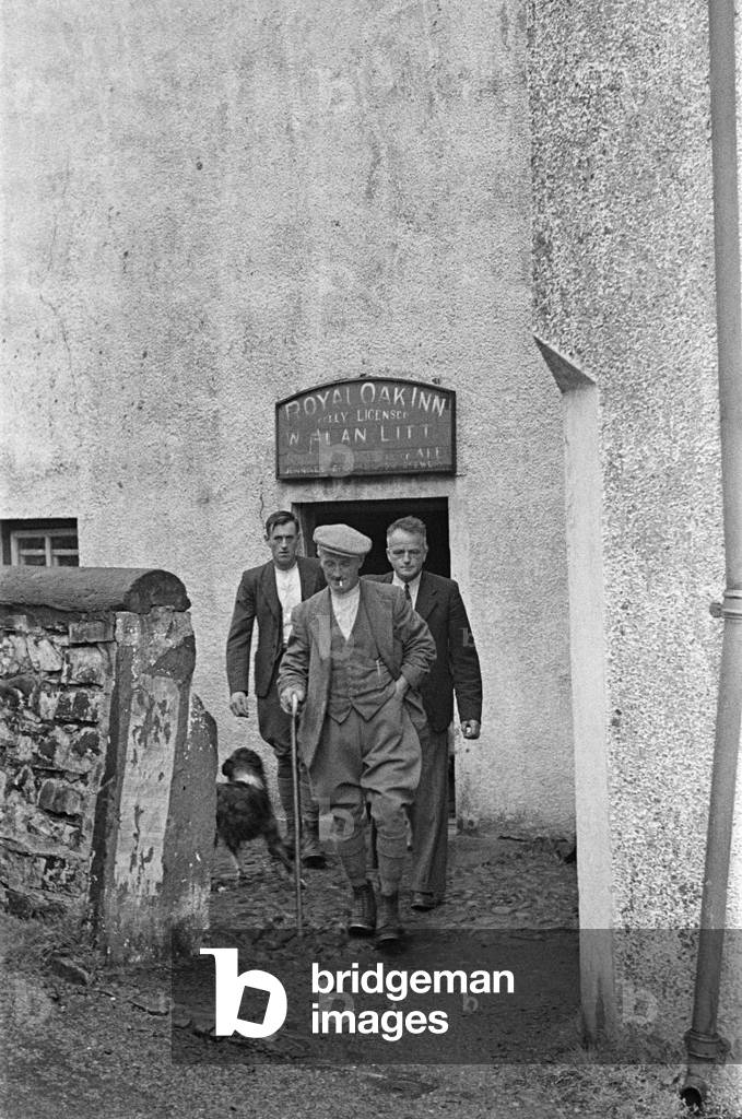 Sheep shearers leaving the Royal Oak Inn to go back to work, in Braithwaite village near Keswick, Cumbria, c. July 1947 (b/w photo)