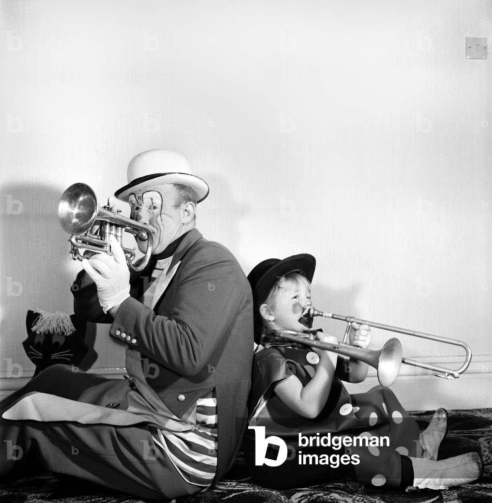 Four year old girl learning how to be a clown like her daddy. Blackpool clown Ernie. December 1969