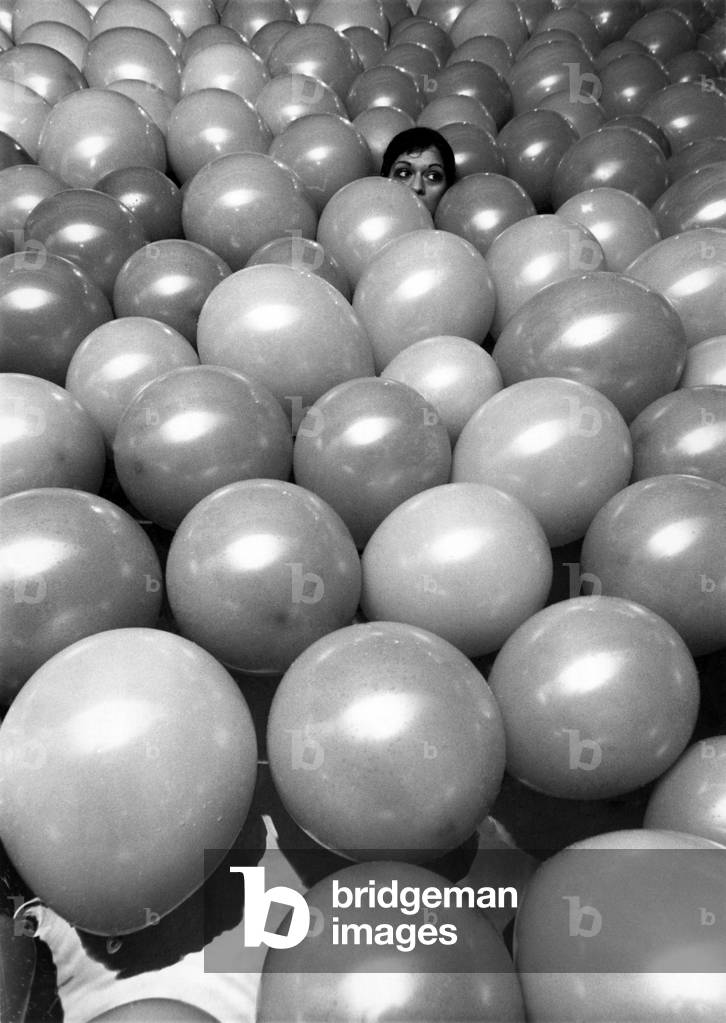 A model looks a little lost, like in the house of mirrors, among the balloons in the White House swimming pool South Kensington, London, 15th November 1968