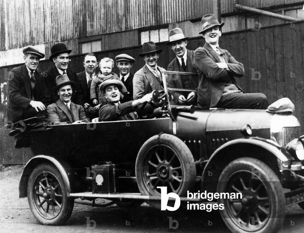 Members of the 1927 FA Cup winning Cardiff City football team and child pose for a photograph in a motor car, circa 1927.