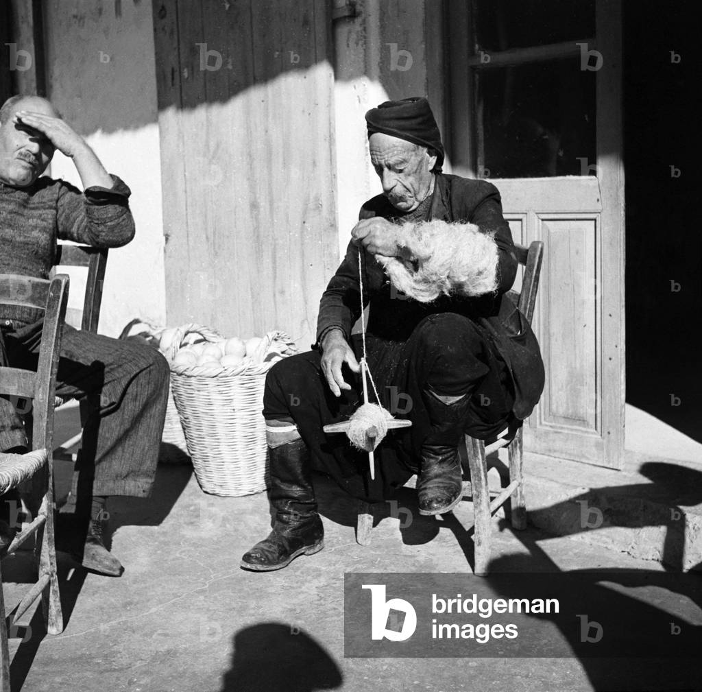 Old Greek Cypriot sitting in Greek cafe and making string an occupation many old man seem to have.