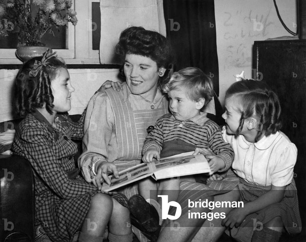 Mother reads a bedtime story to the children. 
December 1944