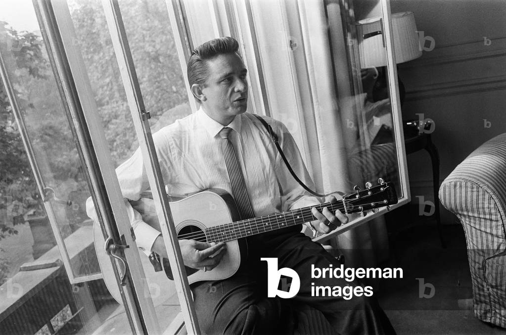 American country singer and musician Johnny Cash poses for photographers at the Savoy Hotel in London. 17th September 1959 (b/w photo)
