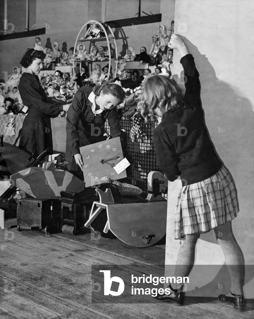 Preview to Santa Clause: Wherever there are toys, sure enough there are children. No matter where the playthings are hidden, a water diviner couldn't do better then a child for finding where they are. Here is a toy cargo from America ready for Christmas, and sure enough here's kiddy taking a peep at the things to come. November 1944