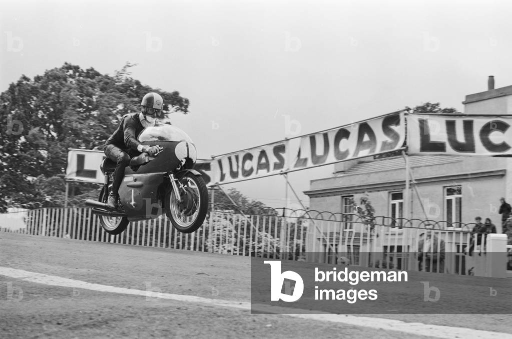 TT Races 250cc Lightweight International. Tarquinio Provini goes over Ballaugh Bridge, 14th June 1965 (b/w photo)