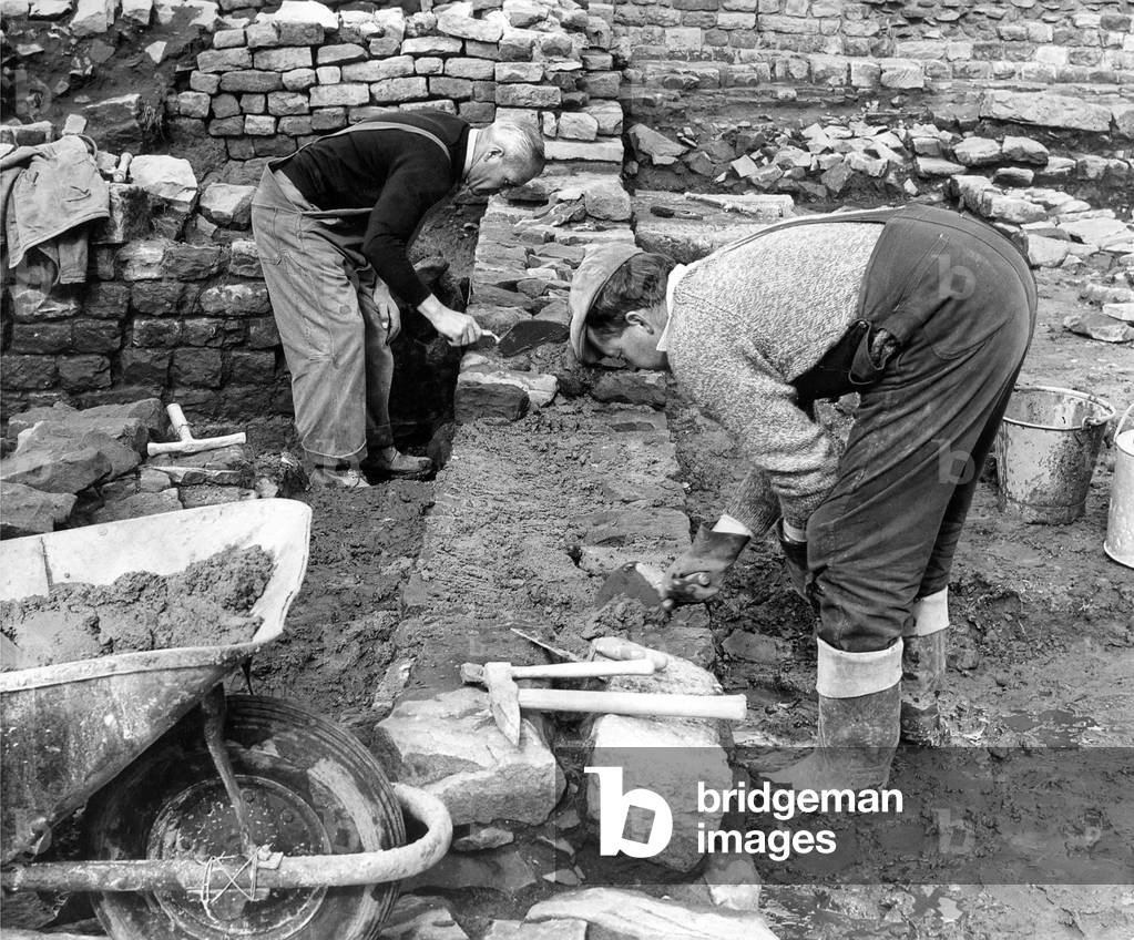 Dan Wilkinson and Raymond Johnson renovating a fresh section of the Roman fort at Housesteads, Northumberland in September 1968 (b/w photo)