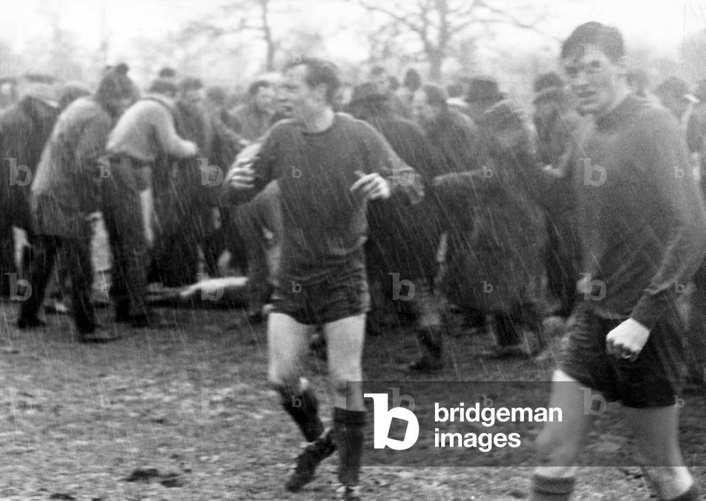 Seconds after a lightning flash leaves unconscious players lying stunned in the mud, spectators crowd round as Highgate United's trainer Albert Bates prepares to give Tony Allden the 'kiss of life'. Team-mates Gordon Cooper (left) and Trevor Jones call for stretchers to get their friends off the field. 25th February 1967 (photo)