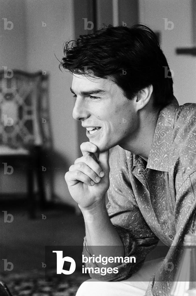 American actor Tom Cruise answers questions during an interview in his hotel suite on a visit to London, after the release of his latest film Top Gun in the United States, 26th June 1986 (b/w photo)