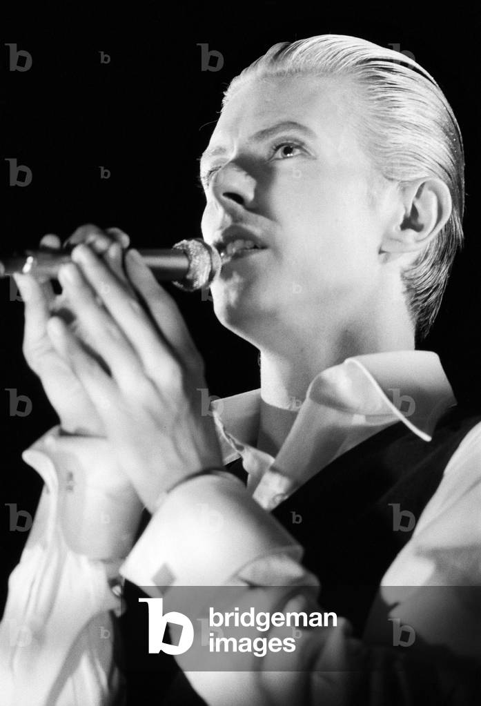 British pop singer David Bowie performing on stage, Wembley, UK, 3rd May 1976 (b/w photo)