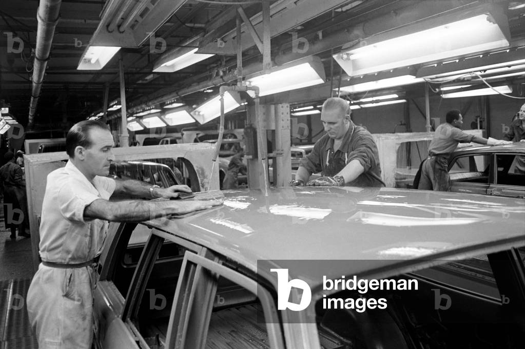 Worker Albert Moss (in white coat) and J. Barrow working on sanding Cortinas in Fords Dagenham motor factory
November 1969