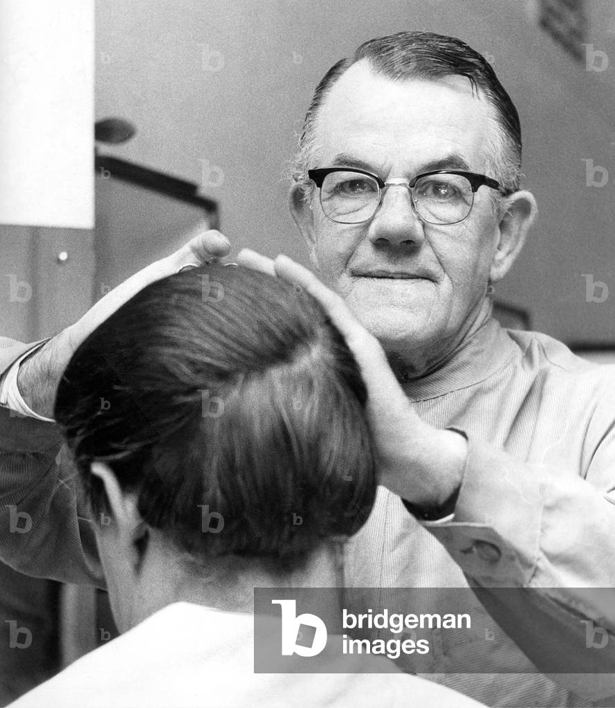 Barber Mr. Fisher hard at work within Bainbridges hairdressing salon in August 1969 (b/w photo)