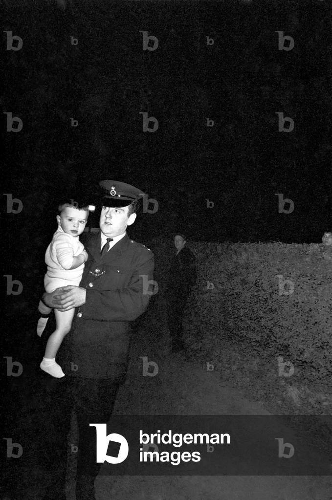 York Terrace, Regents Park, gutted by fire
A policeman with a young child in his arms leaves York Terrace at the height of the fire. The little boy was one of the evacuees placed in an ambulance after the fire broke out. 
November 1969