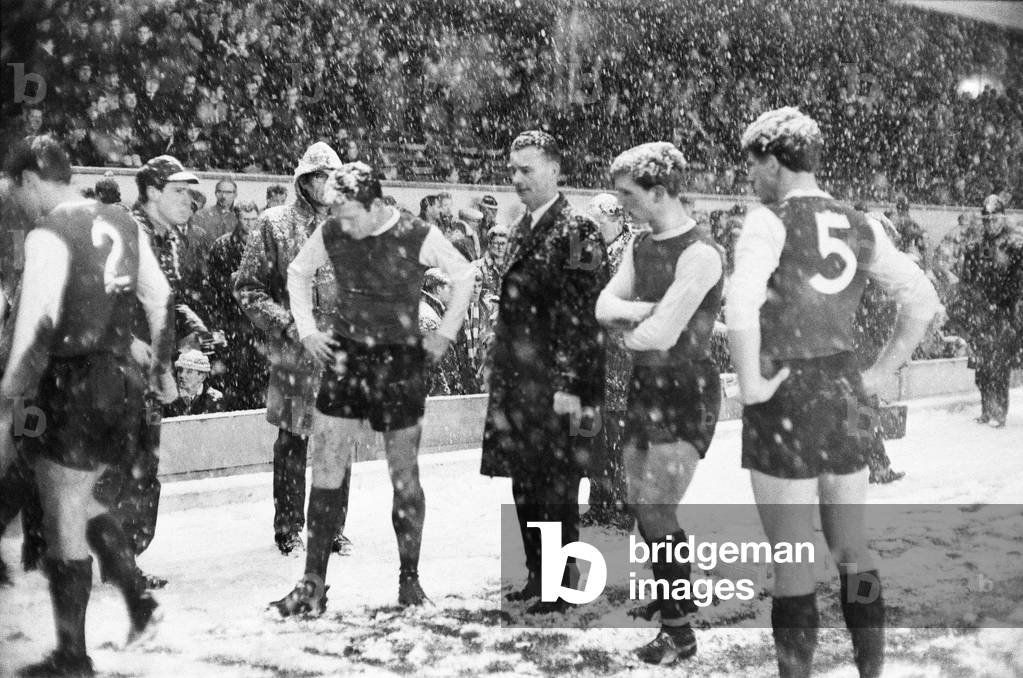 English League Division One match at Highbury, abandoned due to heavy snow. Arsenal v Sheffield Wednesday. Sheffield Wednesday manager Alan Brown surrounded by his players as referee E. T. Jennings walks past to inspect the lines. 9th December 1967 (photo)