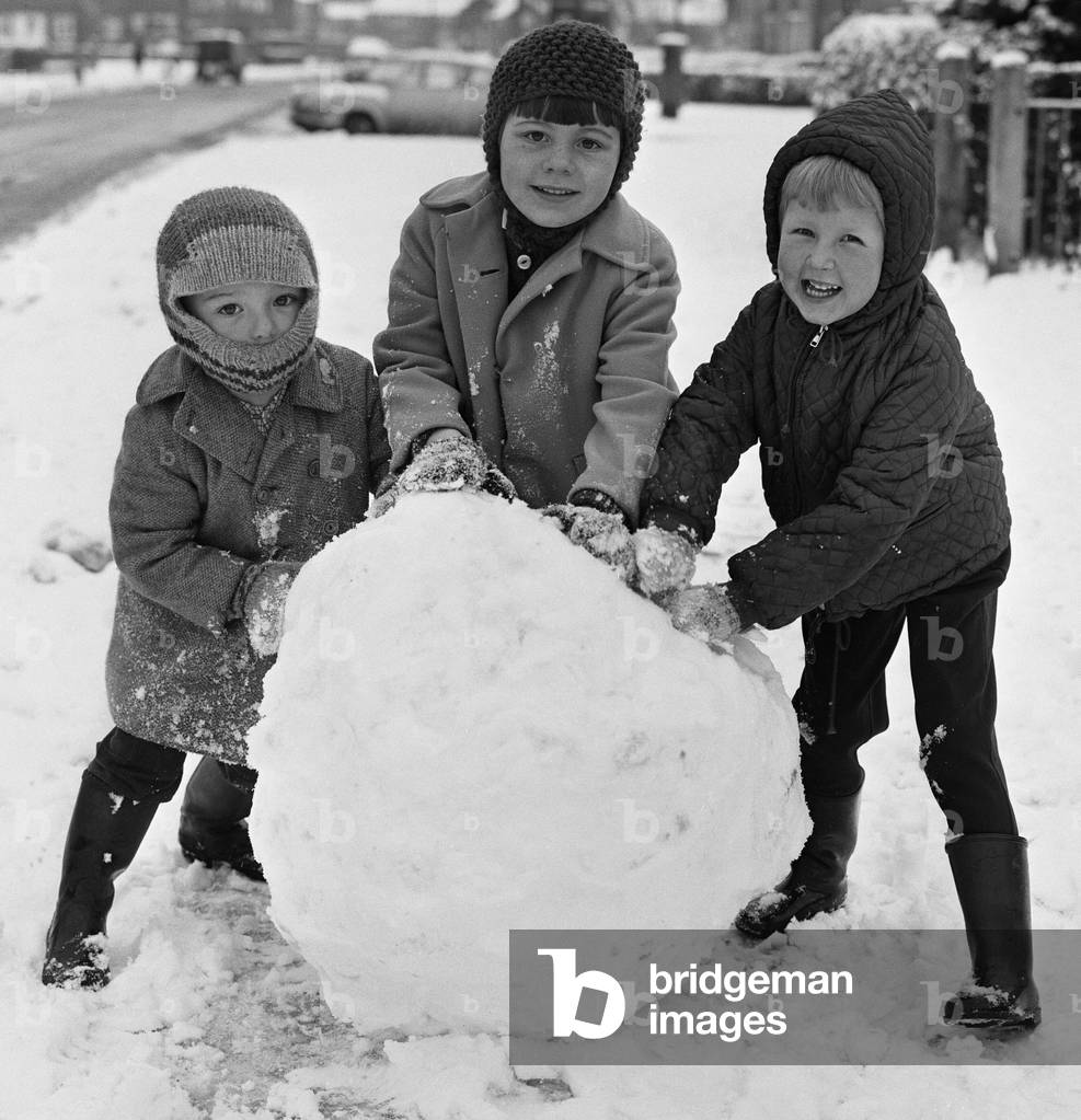 Do you want to build a snowman? Three children seen here in Reading take advantage of the heavy snow fall to build a snowman, c.1968 (b/w photo)