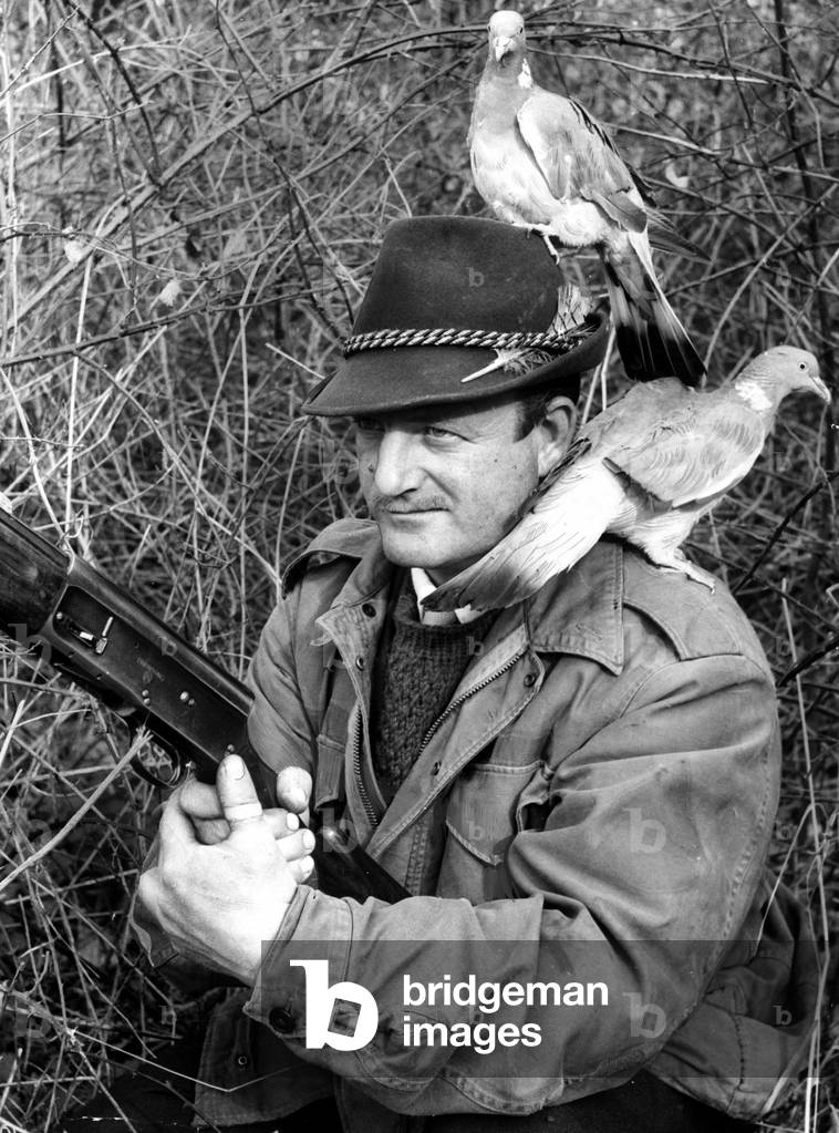 Frank Wright from Norfolk, who uses two tame pigeons he has hand reared as a decoy for pigeons he shoots for a living. 24th May 1963