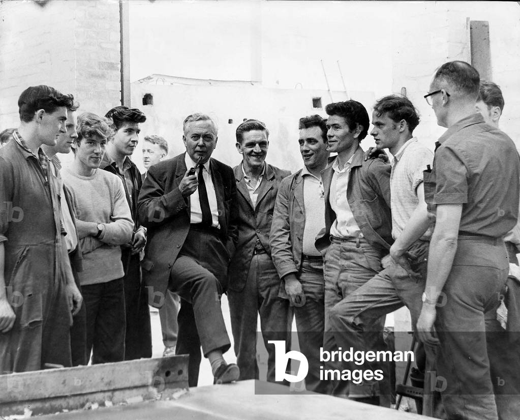 Harold Wilson MP talking with workers at the stock yard of unit construction as he opens a factory at Kirby, Liverpool July 1964 (b/w photo)