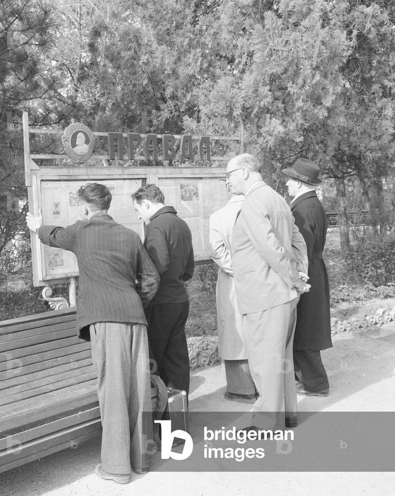 Residents read the official soviet newspaper Izvestia from a public noticeboard in a Simferopol park. April 1960