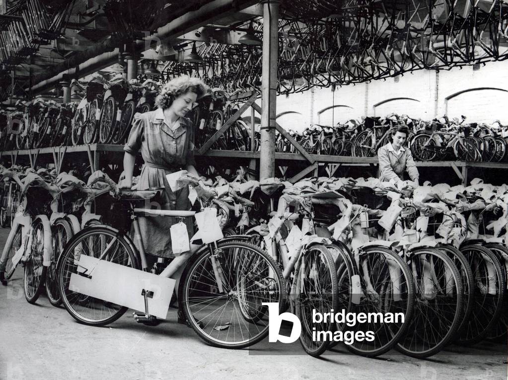 Knowing hat their output helps Britain's export drive, the workers of this big Birmingham bicycle factory completely filled the factory's store after their Bank Holiday rest. In the first half of 1948, 855,156 British cycles were sold abroad. Working Women August 1948 (b/w photo)