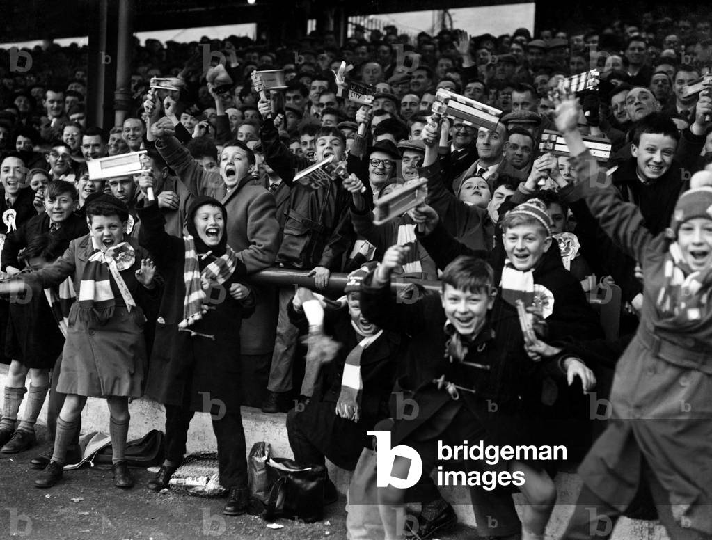 FA Cup Quarter Final match at Filbert Street. Leicester City 0 v Wolverhampton Wanderers 1. Young Leicester fans cheer their team on during the match with their rattles. 26th March 1960 (photo)