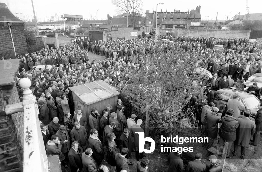 About 8,000 dockers voted to continue their strike this morning with a unanimous show of hands at their meeting at Connaught Corner, E15. Union official Billy Powell and Brian Nicholson, March 1975 (b/w photo)