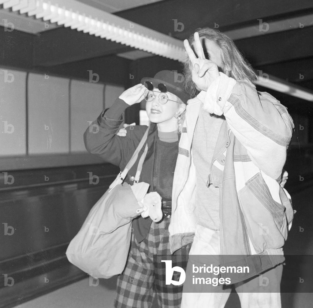 Cyndi Lauper American singer songwriter pictured with manager David Wolff arriving at London Heathrow Airport February 1987 (b/w photo)