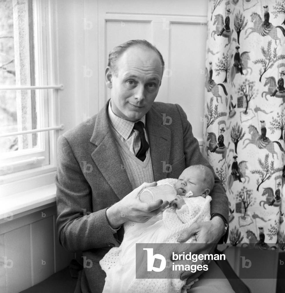 Lord Montagu , pictured on arrival at the Beaulieu, with the baby Ralph, March 1961 (b/w photo)
