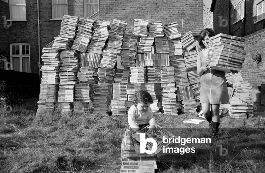 Santa Claus comes early for 14 month old Patrick Flood, as he plays with the dumped games, while his mother Mrs. Juddy Flood, recovers some of the games from the back entrance to her home in Catford. November 1969