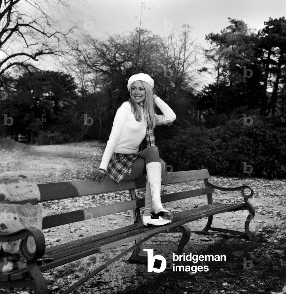 A mini kilt and skinny sweater aren't the ideal clothes for a chilly winter's day but with her matching scarf, bonnet and boots, actress-model Jeanette Will, finds enough courage to brave the winter chills in a Cheshire park. December 1969 Z11784-003