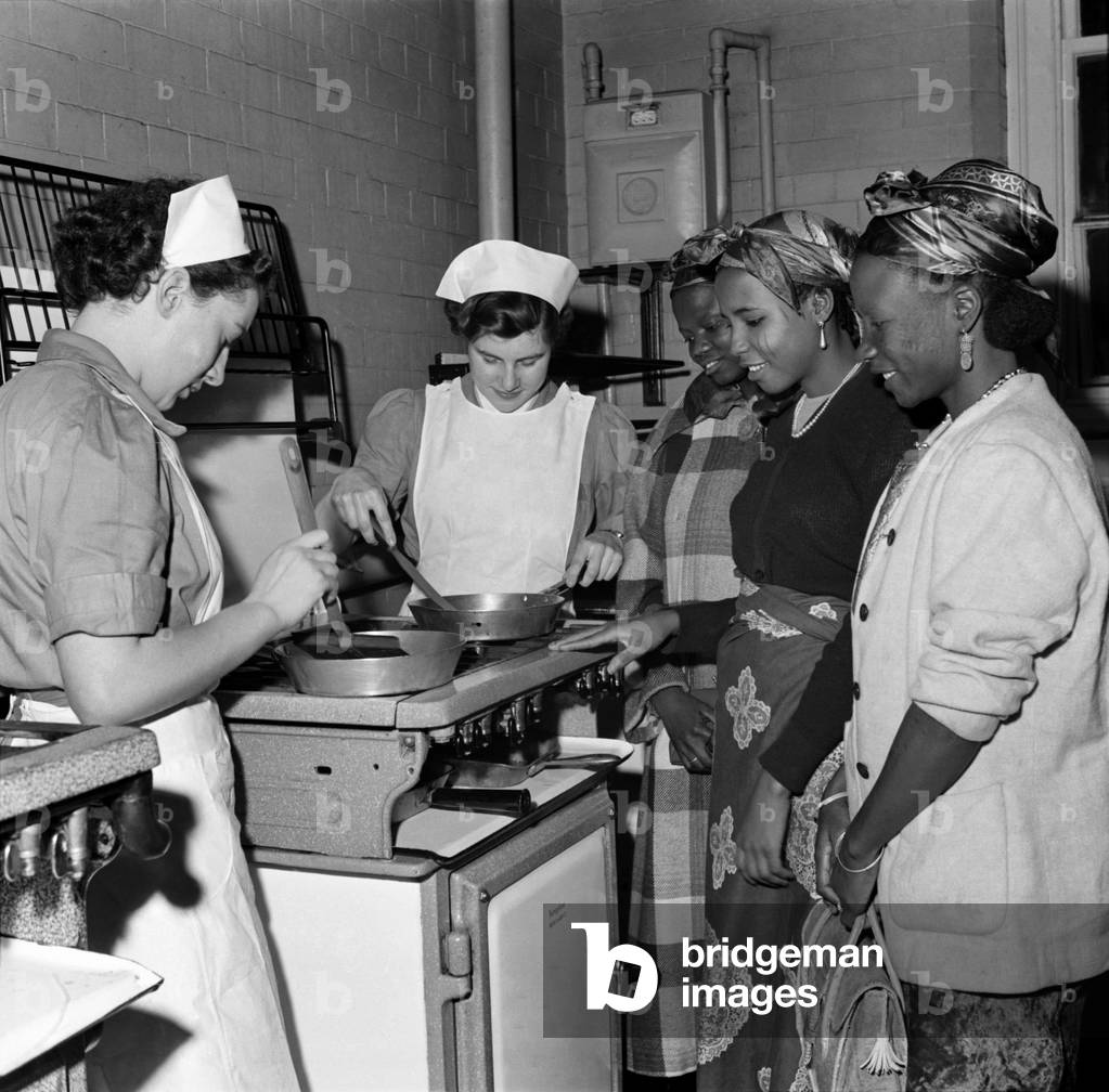 Nigerian women seen here during a visit to the School of Housecraft, in Manchester. The women are watching a cooking demonstration. July 1952 C3411