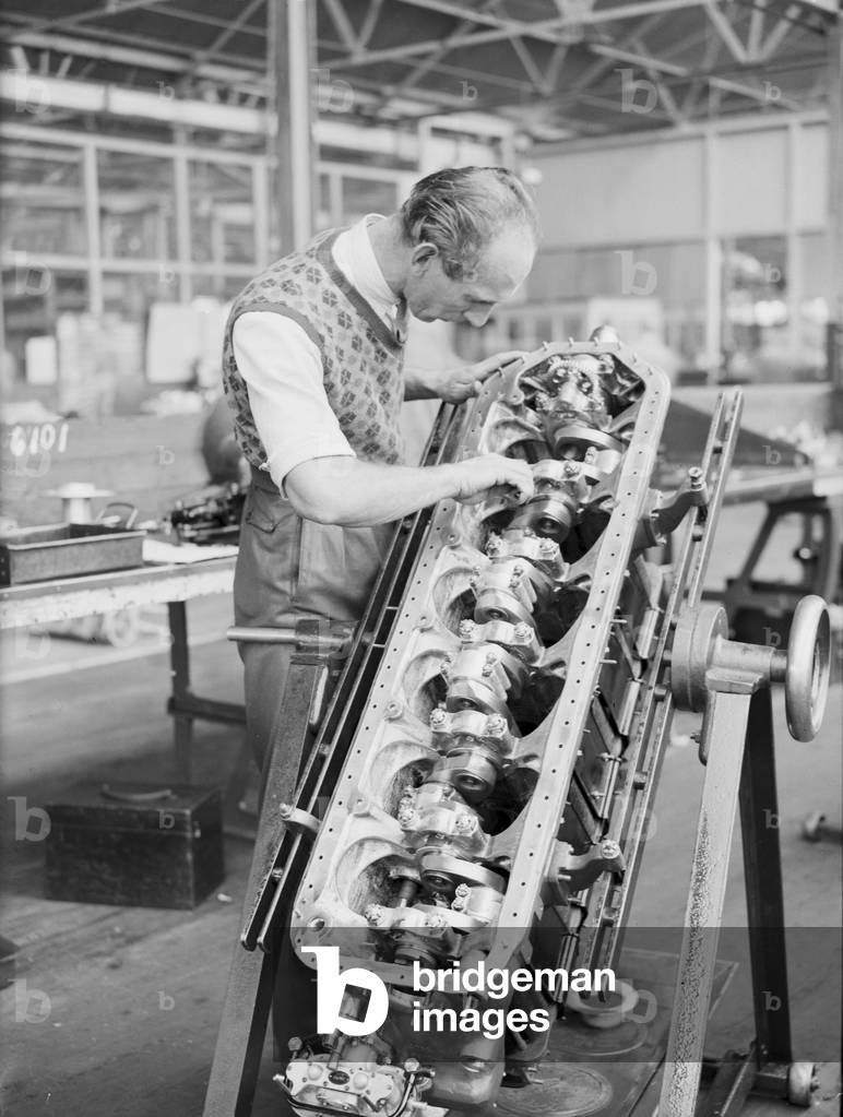 An engineer checks the pistons of the Gipsy Six engine during the construction of the Miles 3 Falcon aircraft at the Philips and Powis factory at Woodley Aerodrome, Reading 2nd April 1934 (b/w photo)