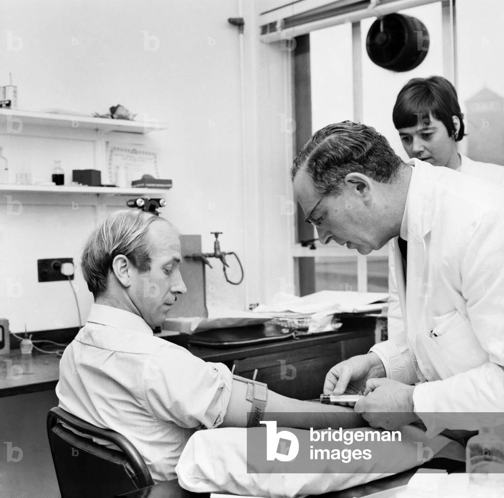 Sport: Football: As part of England's buildup for the 1970 Mexico World Cup, the players visited two hospitals - players pictured here at St. Mary's Hospital for blood tests. An apprehensive Bobby Charlton undergoing a blood test. December 1969 (photo)