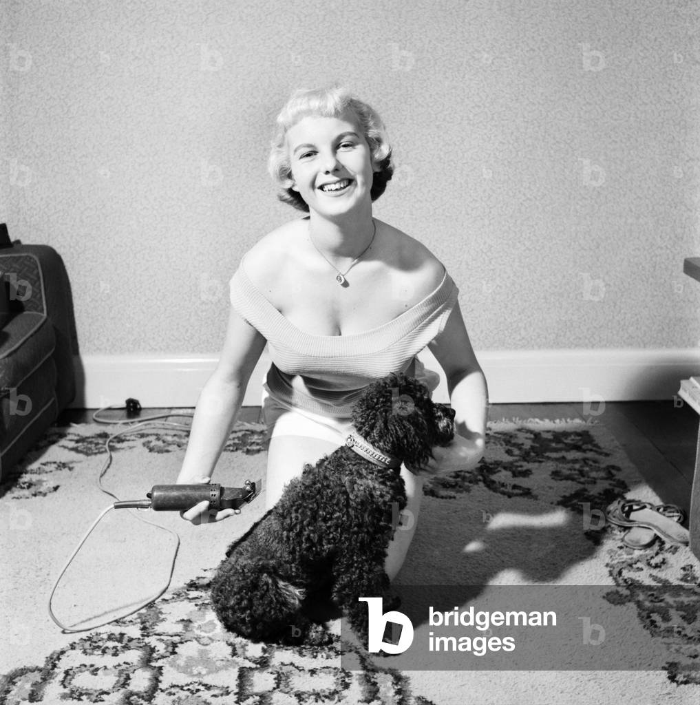 Pat Bolton seen here with her pet poodle dog, 1964 (b/w photo)