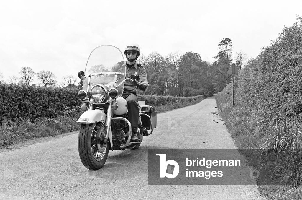American police enthusiast John Hayes wearing the uniform of LA City Police officer and white helmet as he goes for a ride on his Harley Davidson motorcycle. May 1977.