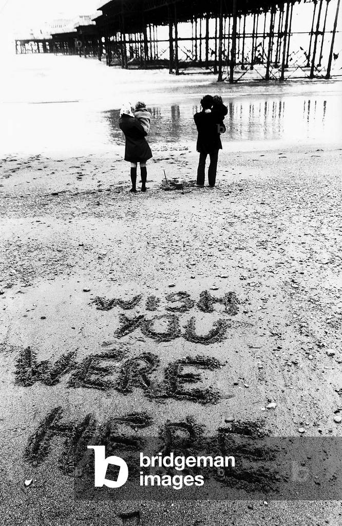 Holidaymakers Mike and Maggie Markham on the beach at Brighton Sussex during a June with the lowest temperatures on record, 28/06/1972 (b/w photo)