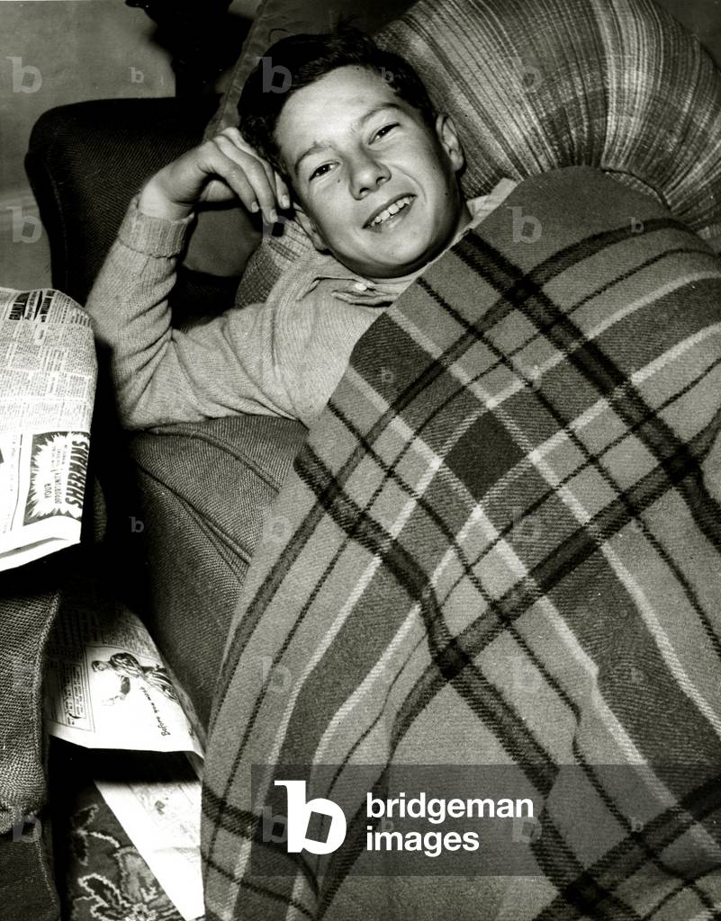 Lester Piggott, the boy jockey, is resting at his home at Lambourn, Berkshire, after being thrown by the racehorse Pandite in the first race at Lincoln. April 1951 (b/w photo)