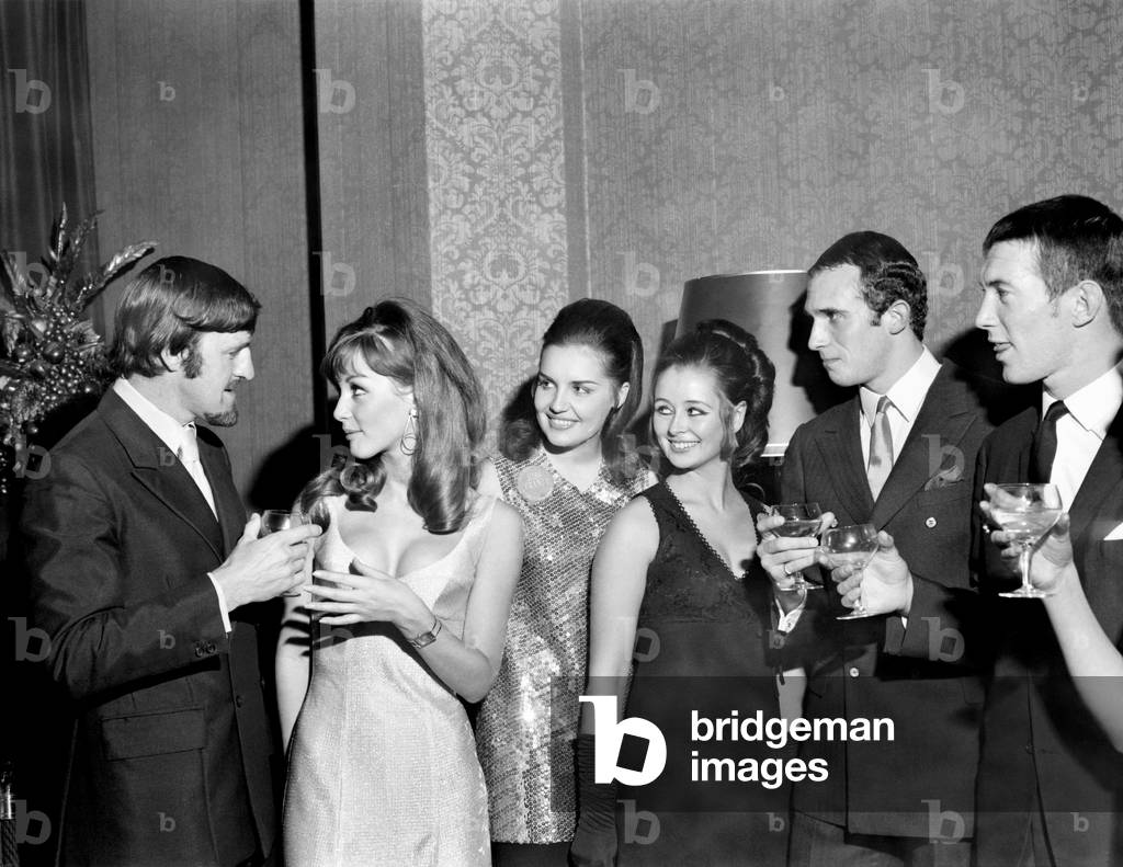 Miss World contestants now in London for the final on the 27th November came face to face with some of Britain's leading sportsmen at a party this evening at the Sportsmans Club, Tottenham Court Road, Three of the girls tug at Jimmy Hill's beard to see if it is real, 1 - r Miss Germany, Christ Margraf (22); Miss France Susanne Angly (18); Miss Gt. Britain, Sheena Drummond (18) from Clackmannanshire, Scotland. November 1969 (photo)
