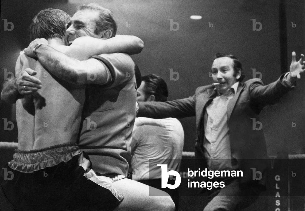 Jim Watt is given a hug by his manager Terry Lawless as a fan runs open armed to congratulate him on his victory over opponent Alfredo Pitalua at the Kelvin Hall, Glasgow. 17th April 1979 (b/w photo)