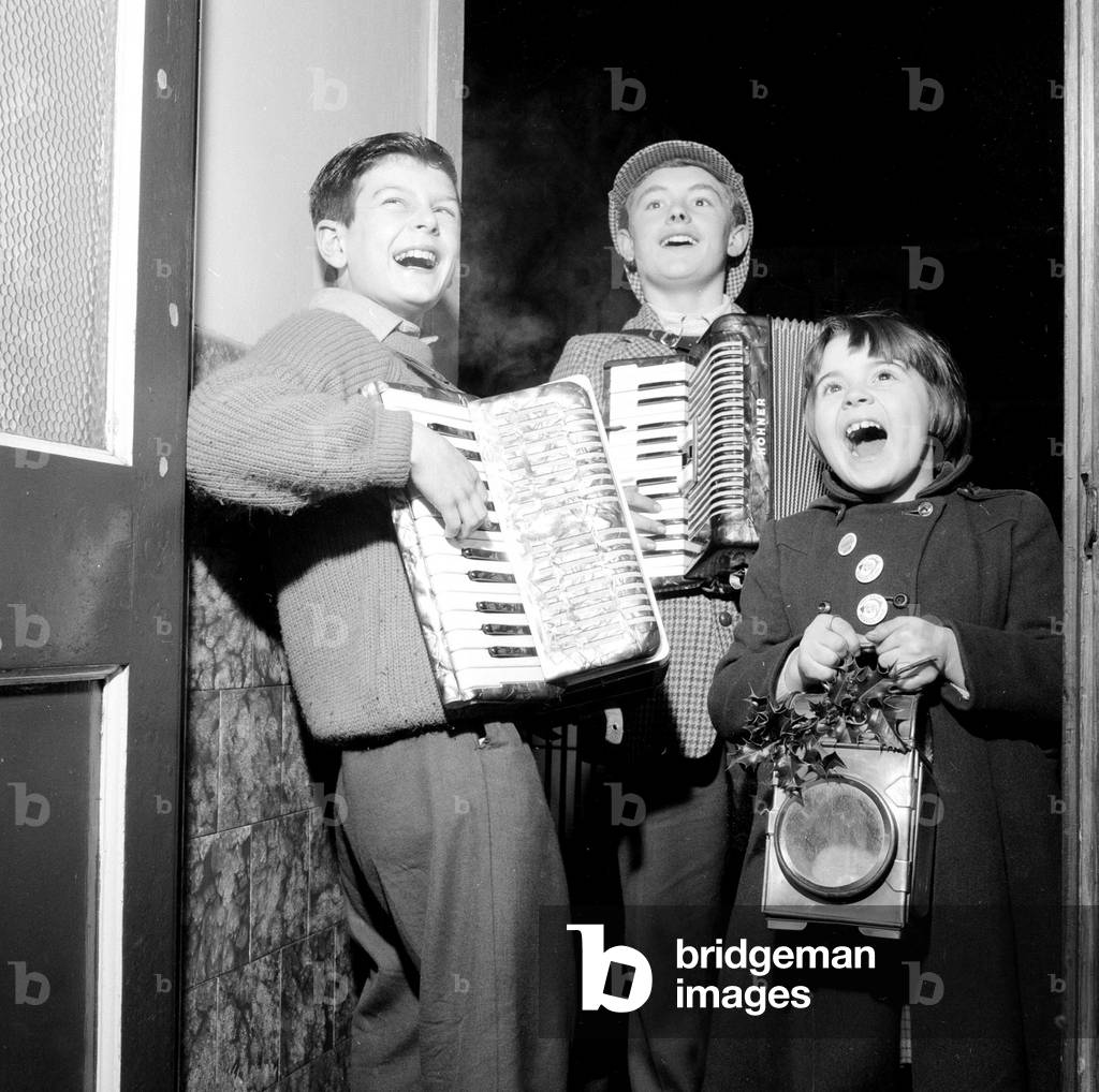 Three Carol singers from Canton, Cardiff, who tour the neighbourhood at Christmas time. Carl Thornby age 14, Clive Kidd age 12 and his sister Susan age 7, pictured at the home of David Freedman. 21st December 1960 (b/w photo)