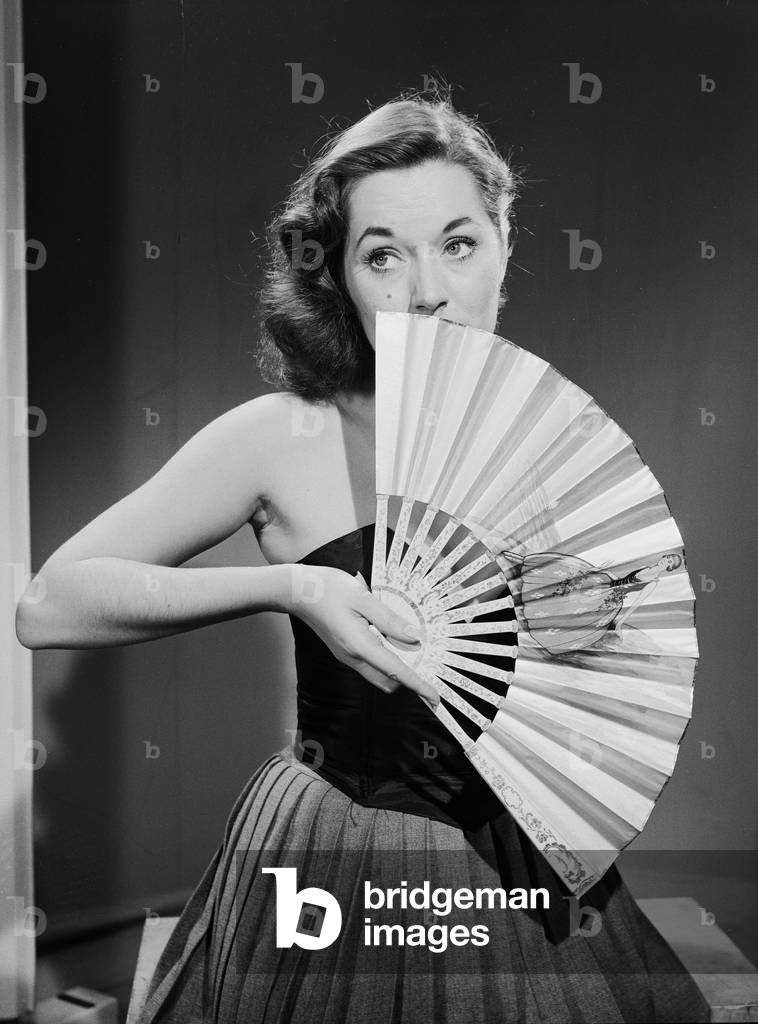 Model with fan in strapless dress. Model with fan in strapless dress., c. 1964 (b/w photo)